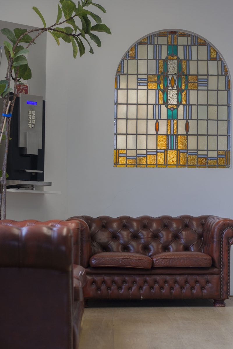 Chesterfield-bank onder een glas-in-loodraam